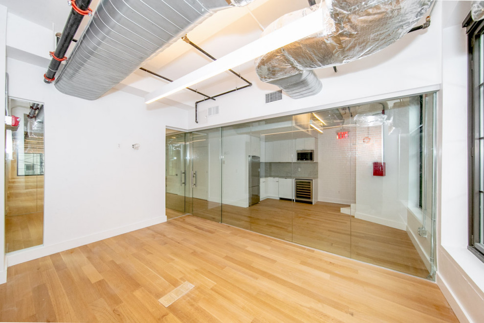 Office floor rehabilitation in the Flatiron District with glass partitions and exposed mechanical systems